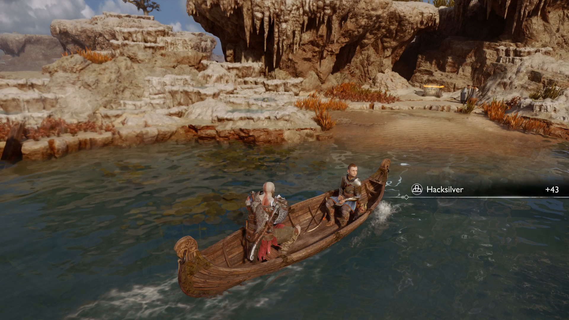 Kratos and Atreus row a boat towards a cache in the Aurvangar Wetlands in God of War Ragnarok