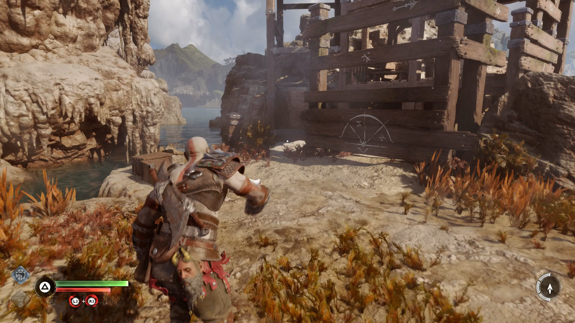 Kratos climbing the path around the water wheel in God of War Ragnarok