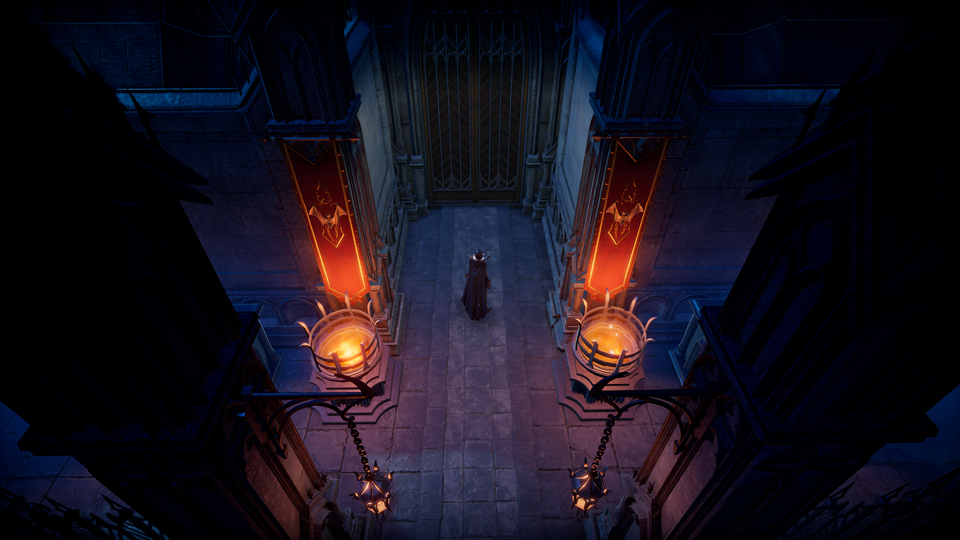 V Rising, a character wearing a cloak is standing in a dark castle hallway made out of stone, large flame-lit torches are either side of them as they look at a large door