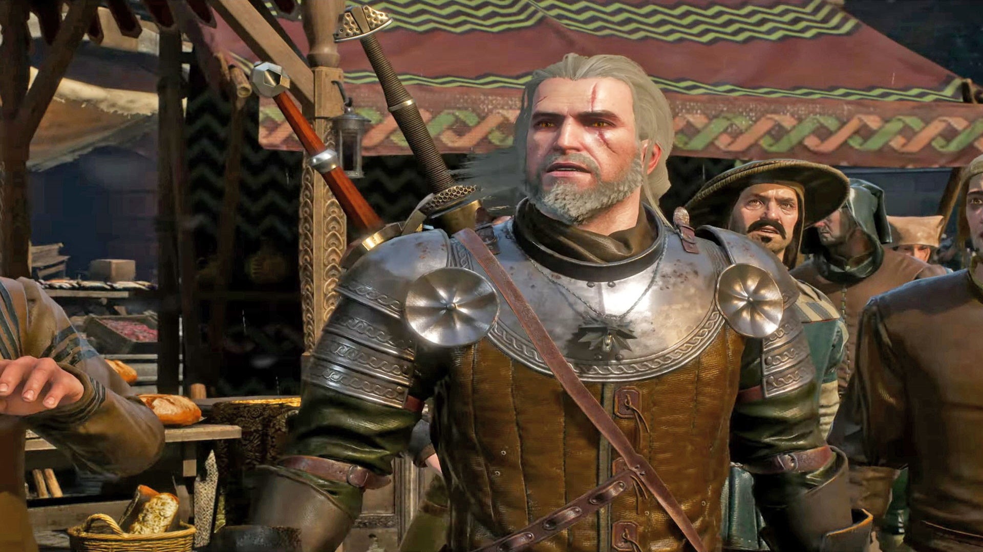 The Witcher 3 best abilities: A white man with shoulder-length grey hair and a short grey beard is standing in the middle of a busy marketplace, near a wooden stall selling bread. He's wearing plate mail on his shoulders and a leather jerkin underneath